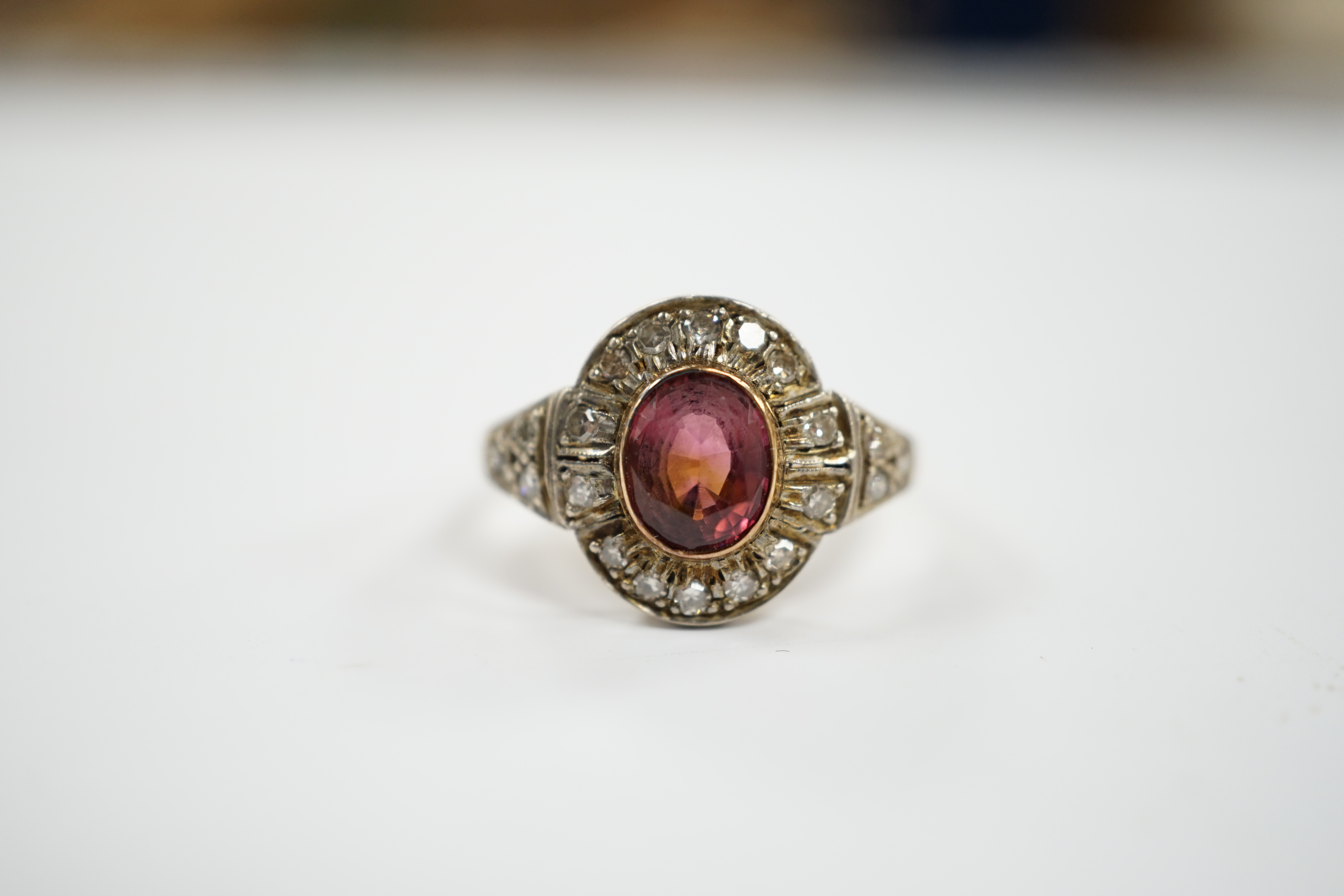 An 18ct, deep pink tourmaline and diamond set oval cluster ring, size P/Q, 4.4 grams